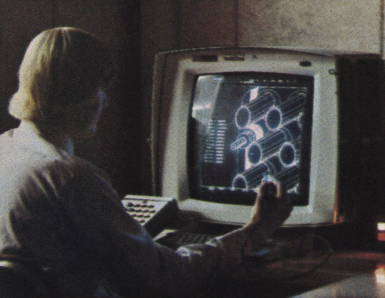 Engineer employed at the Hughes Aircraft Company working on CAD workstation with a light pen in hand